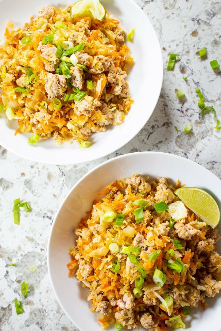 Top view of AIP, Paleo Cabbage Roll Bowls with sliced green onions and lime slices.