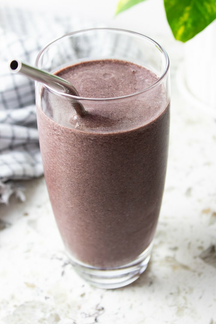 Blueberry Ginger Collagen Smoothie in a glass with a metal straw