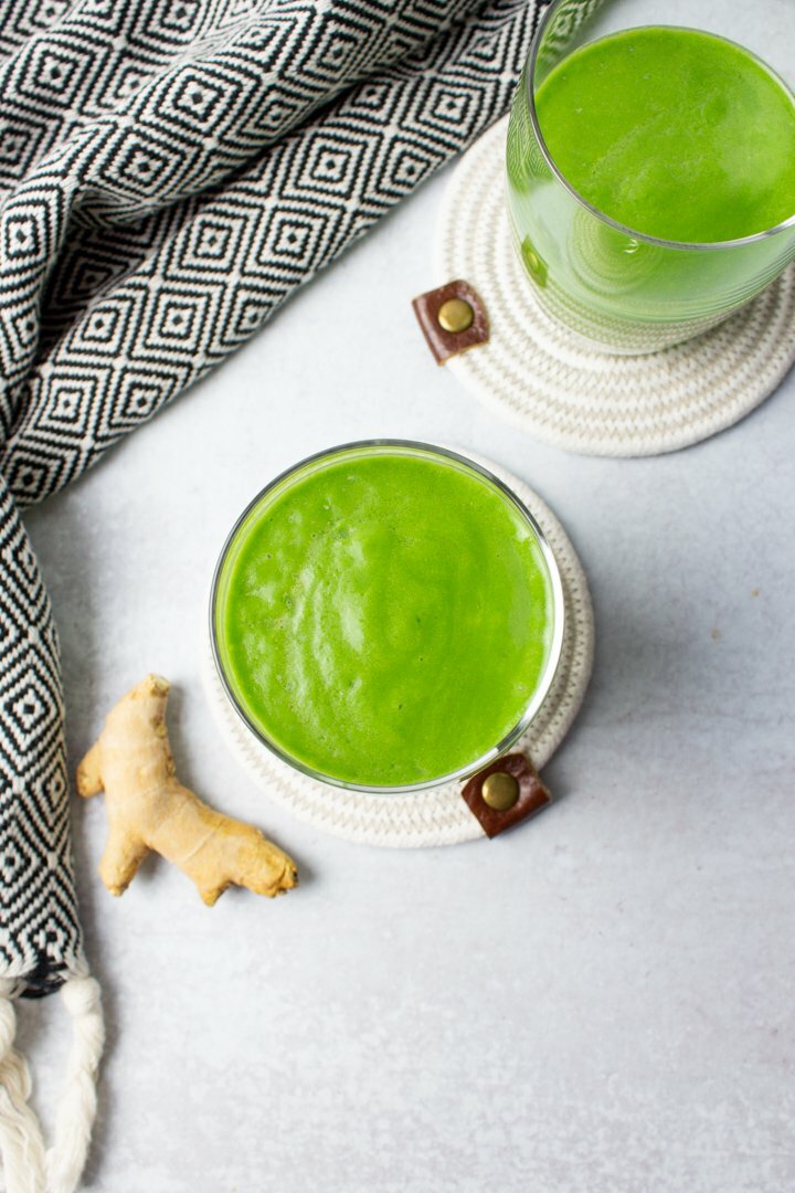 Top view of Banana Ginger Green Smoothies with a piece of ginger off to the side.